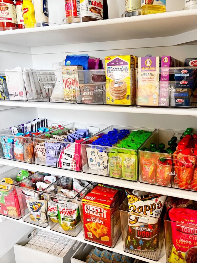 Clear stackable pantry storage bins organizing snacks